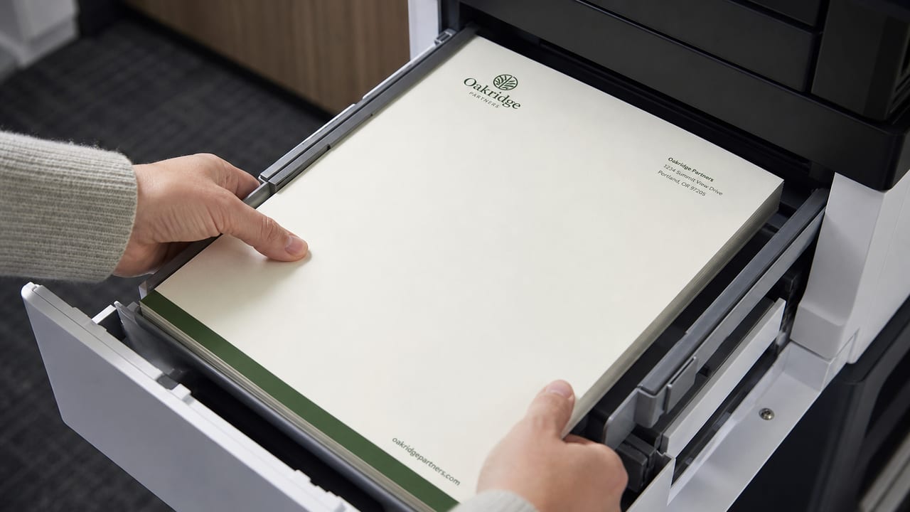 Leeres Briefpapier neben Füller und Wachssiegel auf warmem Holzschreibtisch — Symbol für formellen Absender
